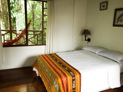a bed in a room with a large window at Pacoche Lodge in Pacoche