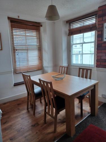 a dining room with a wooden table and chairs at Amazing value, in great location in Plymouth