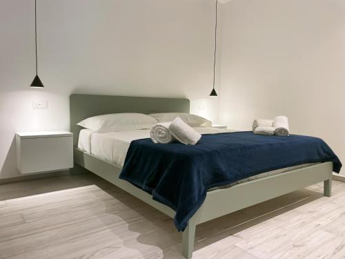 a bedroom with a large bed with a blue blanket at Dione Casa Vacanze Donnalucata - Verde in Donnalucata