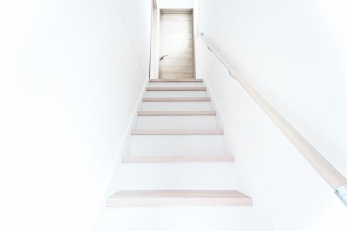 a staircase in an empty room with white walls and white stairs at Degere in Tokyo