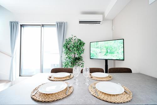 a dining room with a table with plates and glasses at Degere in Tokyo