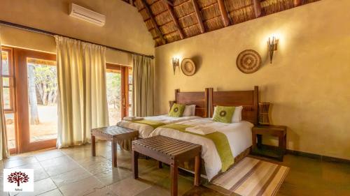 a bedroom with a large bed and a window at Zebula Golf and Wildlife Estate - Oryx Walkway Pax 16 - Moi Signature Luxury villa in Mabula