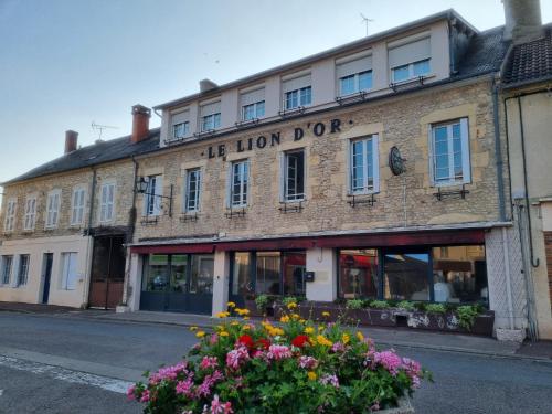 un bâtiment situé dans une rue avec des fleurs devant elle dans l'établissement Chambre Nérondes Le Lion d'Or, à Nérondes