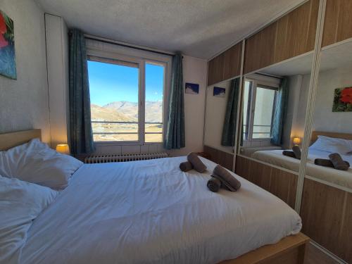 une chambre avec un lit et une grande fenêtre dans l'établissement SLA606 -Charmant 2 pièces, 4 pers - Tignes, à Tignes