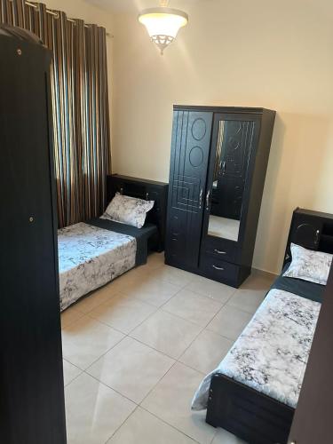 a room with two beds and a mirror in it at Spacious 3BR PLUS MAID ROOM in Sharjah