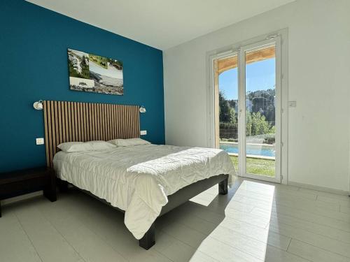une chambre avec un lit et un mur bleu dans l'établissement Villa rénovée avec piscine, clim, proche plages et commerces, 6 pers., Les Issambres - FR-1-768-67, à Roquebrune-sur Argens