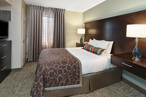 ein Hotelzimmer mit einem Bett und einem Flachbild-TV in der Unterkunft Staybridge Suites Glenview, an IHG Hotel in Glenview