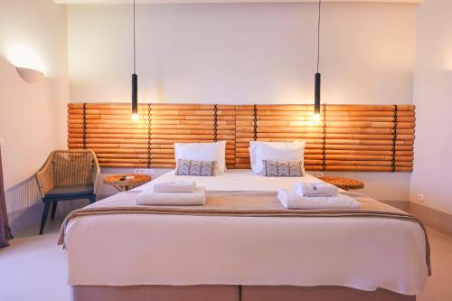 a bedroom with a large bed with two towels on it at Aegean Hospitality in Mýkonos City