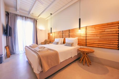 a bedroom with a large bed with a wooden headboard at Aegean Hospitality in Mýkonos City