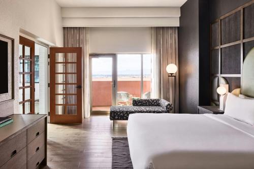 a bedroom with a bed and a living room at Renaissance Phoenix Glendale Hotel & Conference Center in Glendale