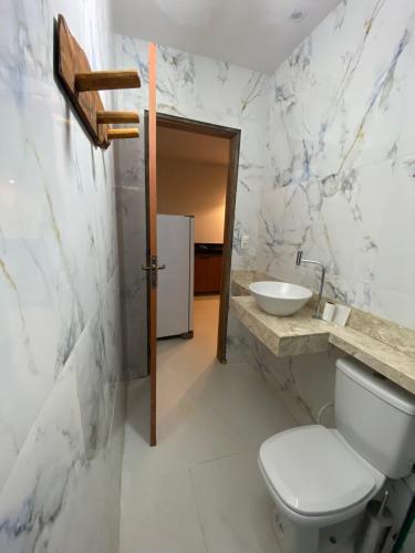 a bathroom with a toilet and a sink at Recanto dos Corais in Marau