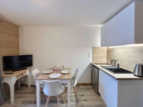 une cuisine avec une table et des chaises dans une cuisine dans l'établissement Appartement cosy avec jardin et parking à Demi-Quartier - FR-1-597-186, à Demi-Quartier