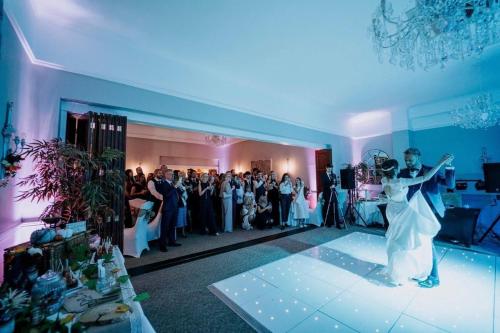 a bride and groom dancing in a room with a crowd at Dovecliff Hall Hotel in Burton upon Trent