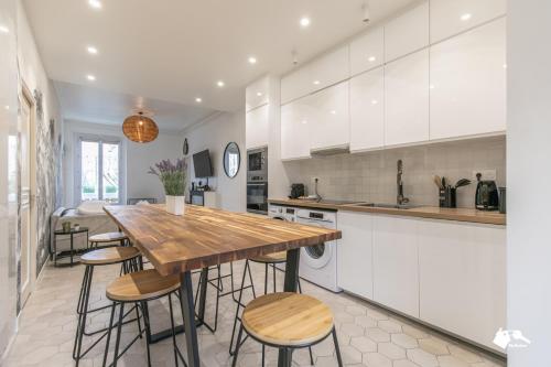- une cuisine avec une table et des tabourets en bois dans l'établissement MBA - Luxury Appart - proche Metro RER, à Le Raincy