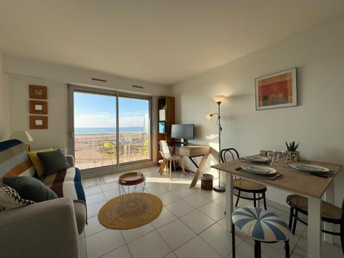 un salon avec un canapé et une table dans l'établissement L'écrin bleu - Vue Mer - Wifi - Central, à Pornichet