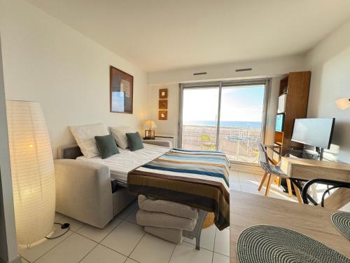 une chambre avec un lit, un bureau et une fenêtre dans l'établissement L'écrin bleu - Vue Mer - Wifi - Central, à Pornichet