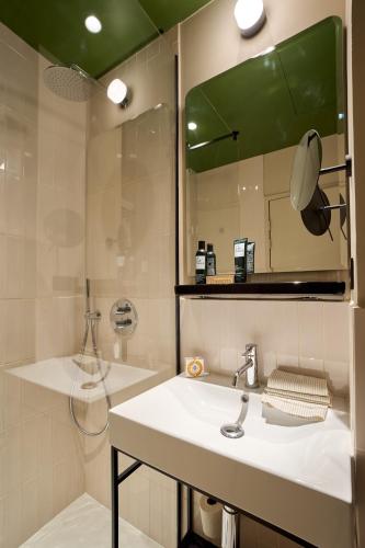 une salle de bain avec un lavabo, un miroir et une douche dans l'établissement 6 VH Hotel, à Paris