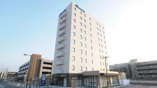 un edificio blanco alto en una calle con edificios en AB Hotel Tahara, en Tahara