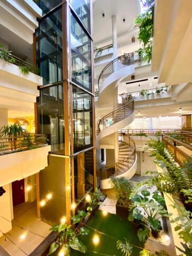 a large building with stairs and plants in it at Barco El Nido Hotel in El Nido