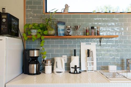 a kitchen counter with a coffee maker and appliances on it at ワンちゃんと泊まれるコテージ　西野納屋 in Kujukuri
