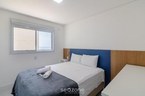 a bedroom with a bed and a window at Condomínio a beira-mar c/ piscina - SHC in Piçarras