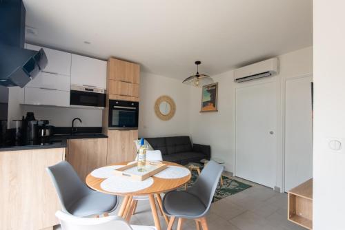 une cuisine et un salon avec une table et des chaises dans l'établissement Ethnia, maison avec spa, jardin privé proche Lac, à Biscarrosse