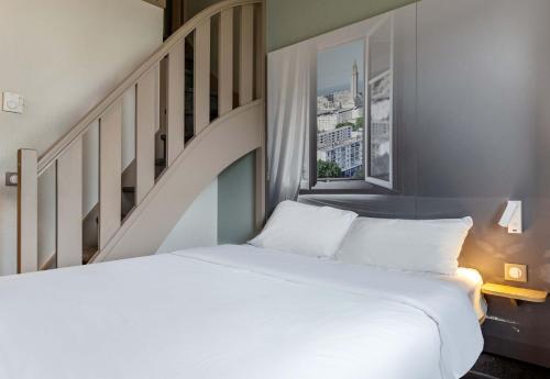 a bedroom with a white bed and a staircase at B&B HOTEL Le Havre Harfleur 1 in Port de Harfleur