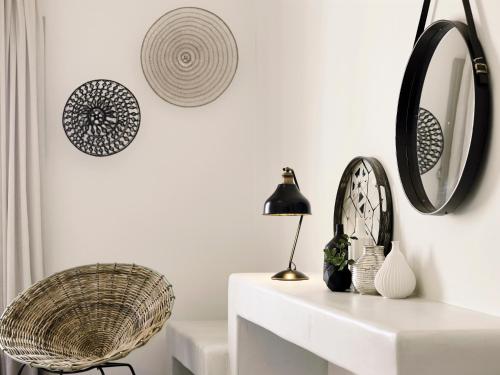 a living room with a chair and mirrors on the wall at Santo Pure Oia Suites & Villas in Oia