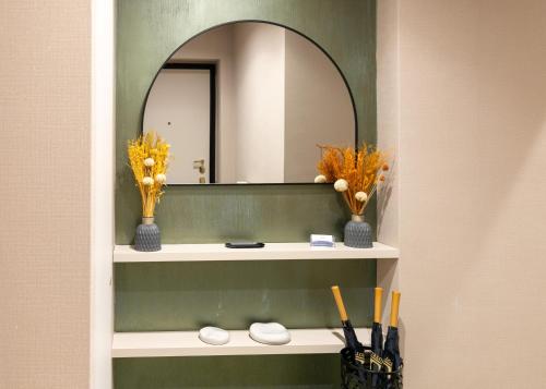 a bathroom with a mirror and a shelf with flowers at Aiello Hotels - Isola Design District in Milan