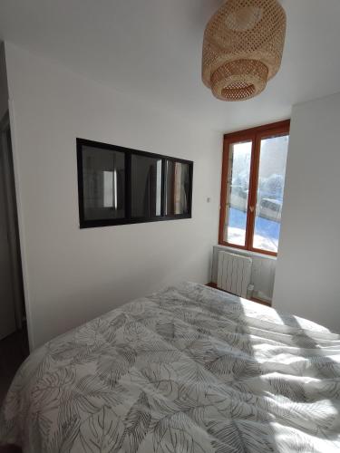 une chambre avec un lit et une fenêtre dans l'établissement O fil de l'o, à La Bourboule