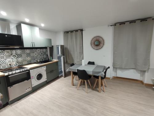 une cuisine et une salle à manger avec une table et des chaises dans l'établissement O fil de l'o, à La Bourboule