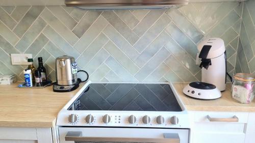 a white stove top oven in a kitchen at COCOON Neuf - Climatisé - Centre ville in Cogolin