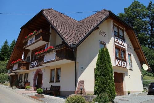 a building with flowers on the windows and a roof at Landgasthof Adler Pelzmühle in Biederbach Baden-Württemberg