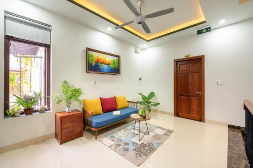 a living room with a couch and a window at Phuoc Dat Riverside Homestay Hoi An in Hoi An
