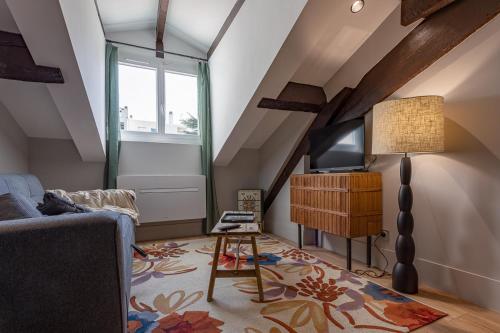 un salon avec un canapé bleu et une télévision dans l'établissement Le Vintage - Studio cosy en hypercentre, à Toulouse