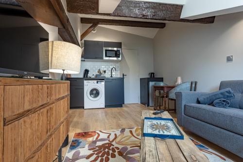 un salon avec un canapé bleu et une cuisine dans l'établissement Le Vintage - Studio cosy en hypercentre, à Toulouse