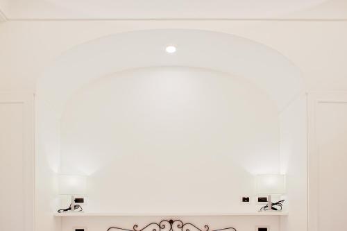 a mirror with two lights on a wall at Hotel Aurora in Amalfi