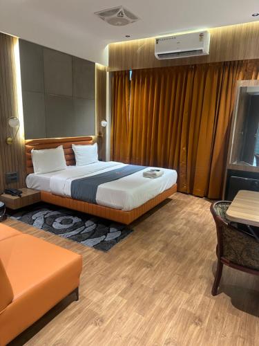 a hotel room with a bed and a couch at Hotel victoria prime in Surat
