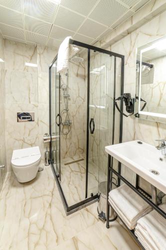 a bathroom with a shower and a toilet and a sink at World Heritage Center Hotel in Istanbul