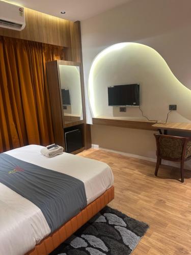 a hotel room with a bed and a flat screen tv at Hotel victoria prime in Surat