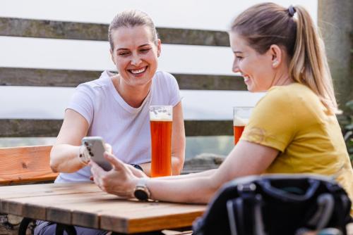 two women sitting at a picnic table with beer at Schatz.Kammer Burg Kreuzen in Bad Kreuzen