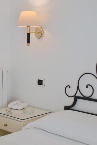 a glass table with a lamp on top of a bed at Hotel Aurora in Amalfi