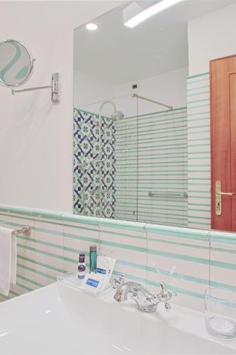 a bathroom with a sink and a mirror at Hotel Aurora in Amalfi