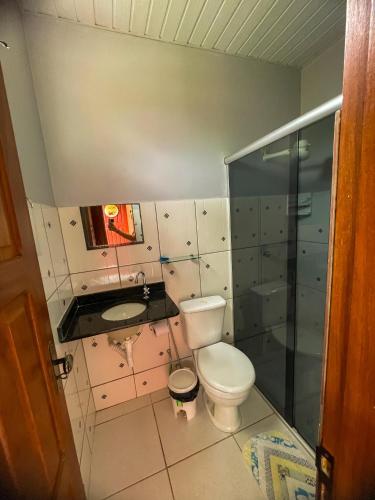 a bathroom with a toilet and a sink and a shower at Pousada Vila da Praia in Santarém