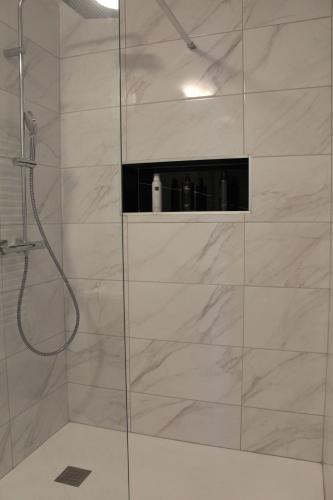 une salle de bain avec une douche avec une porte vitrée dans l'établissement Mon nuage de Saint-Alyre, à Clermont-Ferrand