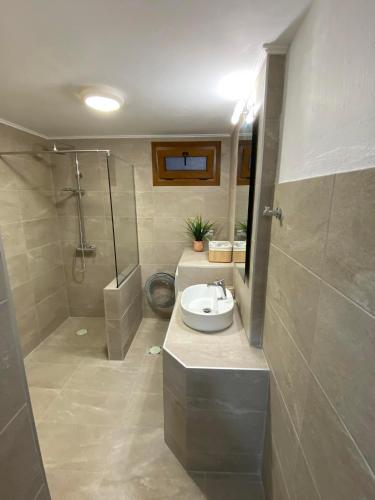 a bathroom with a sink and a shower at Elsa's Poem in Paralia Katerinis