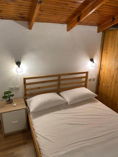 a bedroom with a bed with white sheets and two lights at Elsa's Poem in Paralia Katerinis