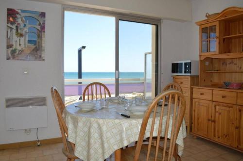 une cuisine avec une table avec des chaises et une vue sur l'océan dans l'établissement Appartement 2 pièces 4 couchages ST CYPRIEN PLAGE SC650-008, à Saint Cyprien Plage
