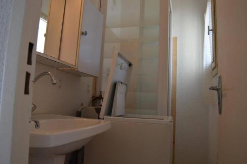 une salle de bain blanche avec un lavabo et un miroir dans l'établissement Appartement 2 pièces 4 couchages ST CYPRIEN PLAGE SC650-008, à Saint Cyprien Plage