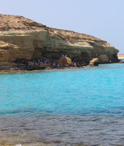 a group of people standing in a cave in the ocean at Ageeba Beach Challet 17 in Marsa Matruh